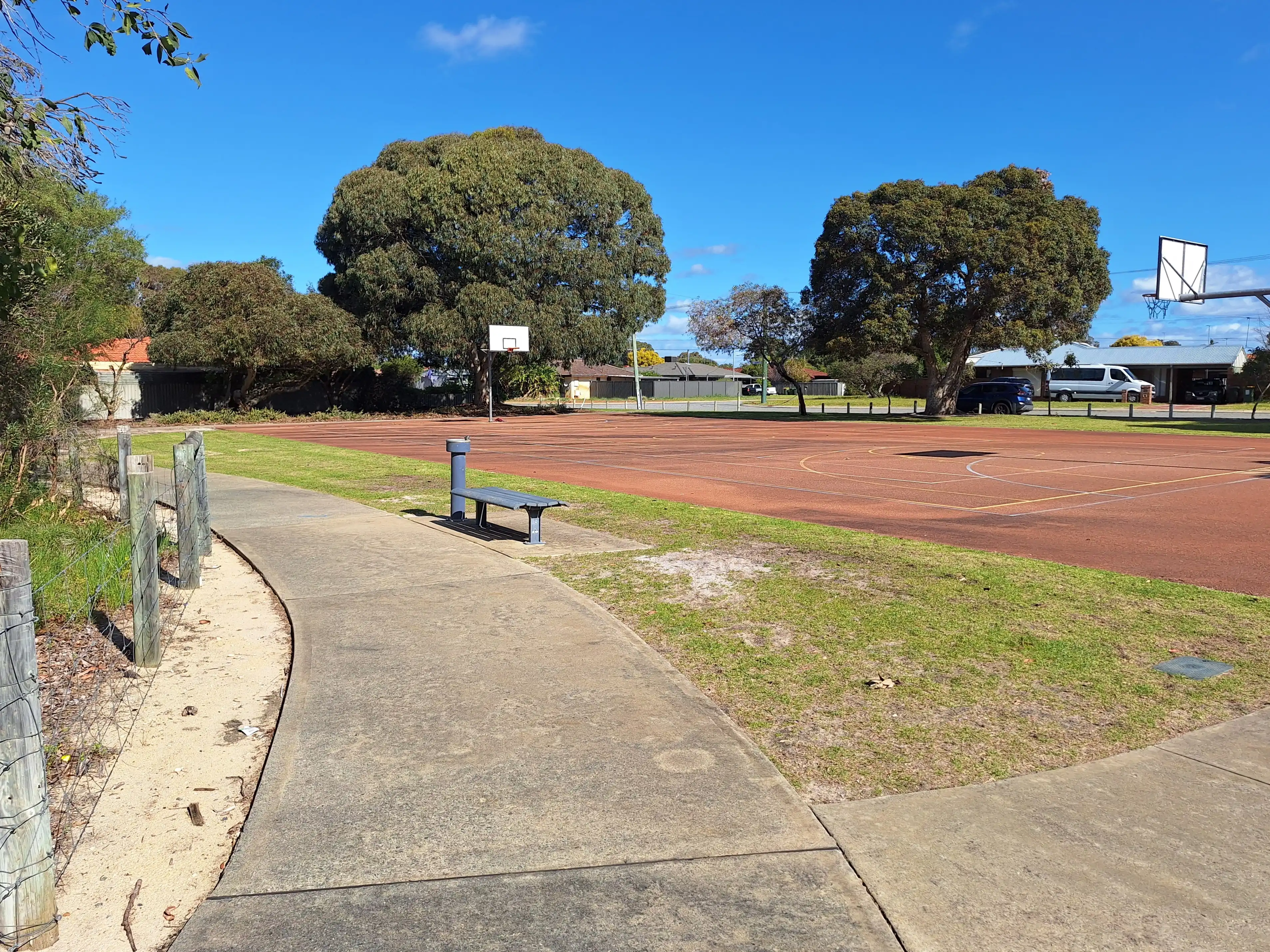Landscape image showing basketball courts in small park